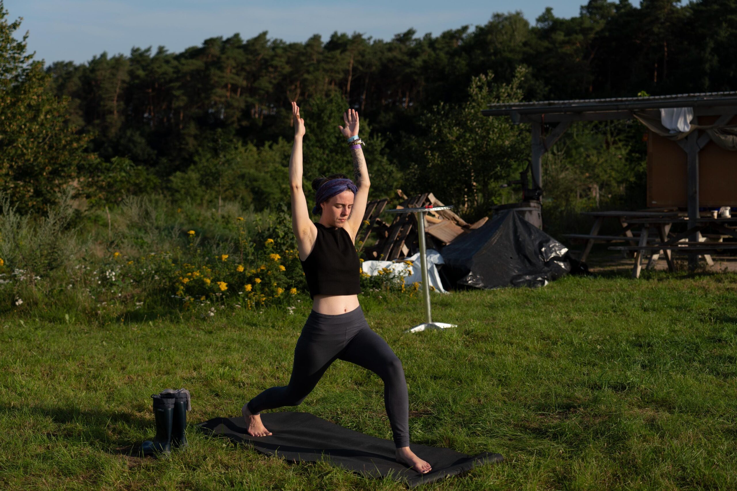 Frau macht die Yoga Krieger Position auf dem CAIA Tribe Gathering